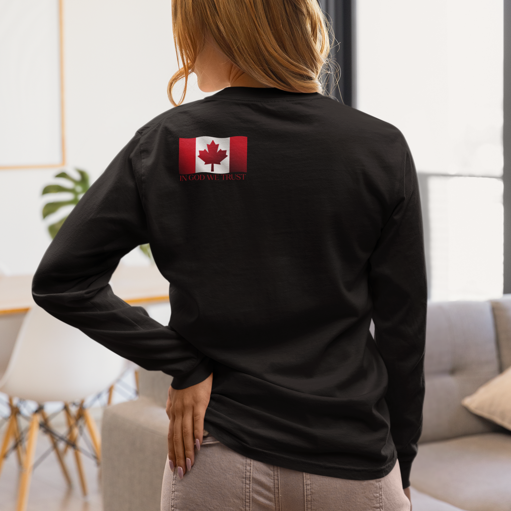 On the back left shoulder blade of this unisex long sleeve shirt is a red Canadian flag that has the words In God We trust underneath the flag, perfect for those wishing to represent God and their country.