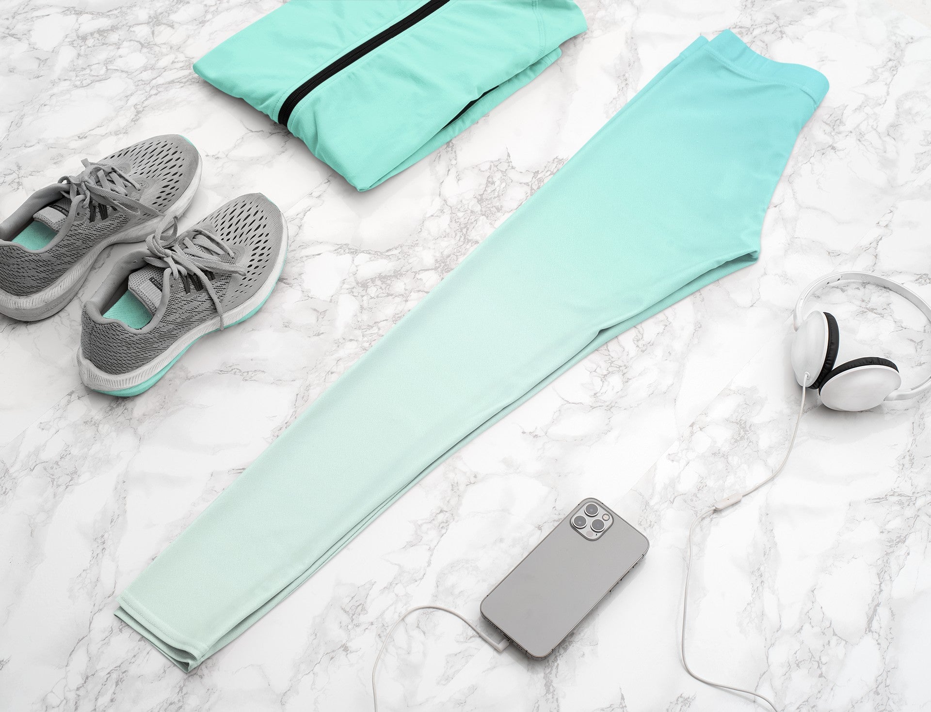 A pair of women's high waisted ankle length leggings that have a ombre pattern that starts as a medium ocean blue at the waistline then fades to a very light sky blue at the ankles of the pant.