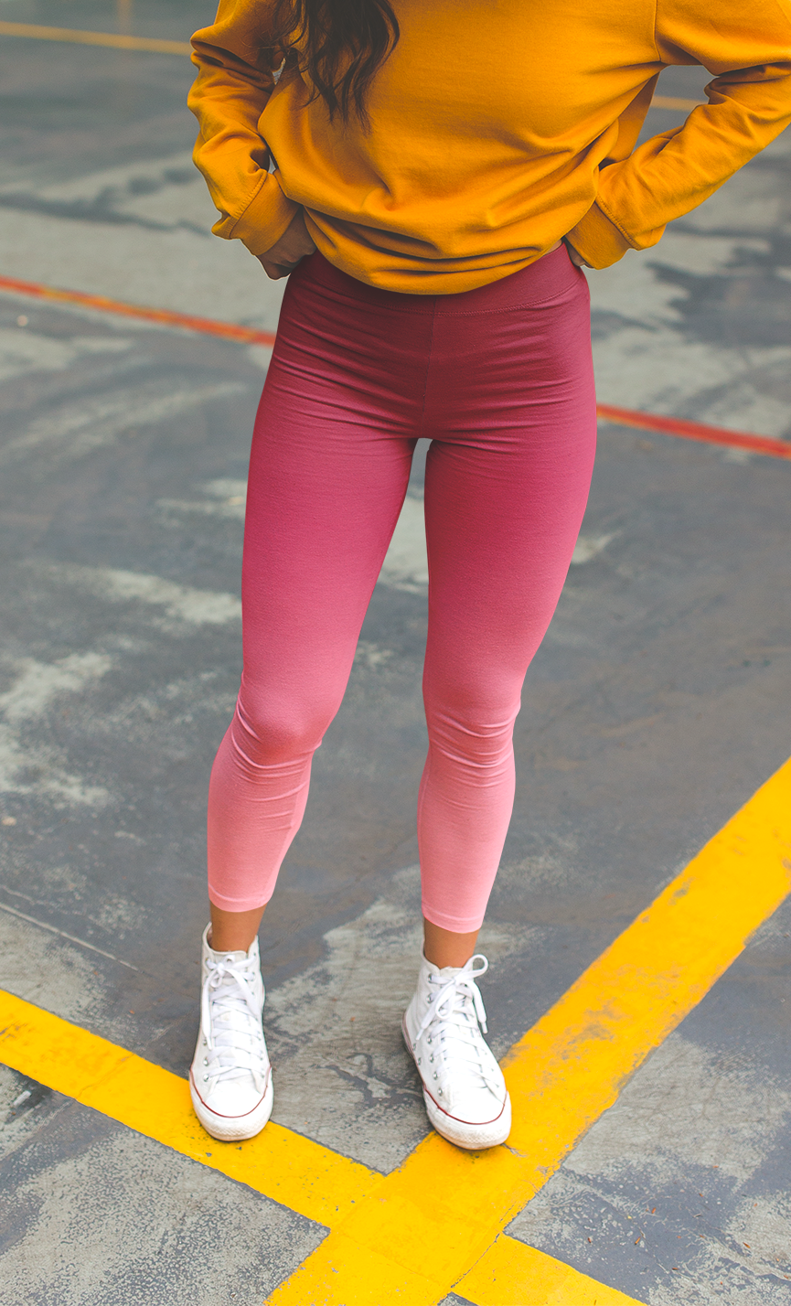 These custom handmade women's high waisted leggings have a pink ombre design with the top of the pants being a dark pink then it fading to a light baby pink at the ankles of the pants.