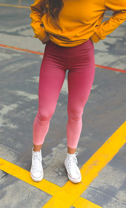 These custom handmade women's high waisted leggings have a pink ombre design with the top of the pants being a dark pink then it fading to a light baby pink at the ankles of the pants.