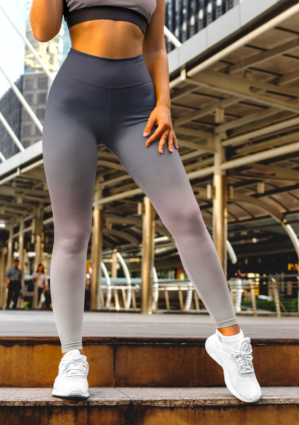 A pair of women's custom high waisted leggings that have an ombre pattern that starts as black at the top of the leggings then fades to a light pink in the middle then to a beige at the bottom of the pants.