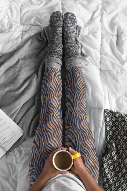 Custom women's high waisted leggings that are beige in color with black lines overtop that look like animal print like that of tigers.