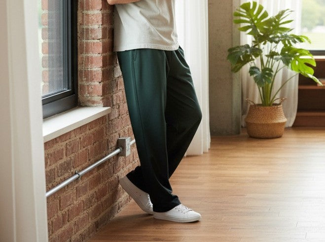 A custom pair of handmade unisex joggers that have an ombre pattern, the top of the pants have a teal green color that shifts to black at the bottom of the sweatpants, there is a black tie around the waist.