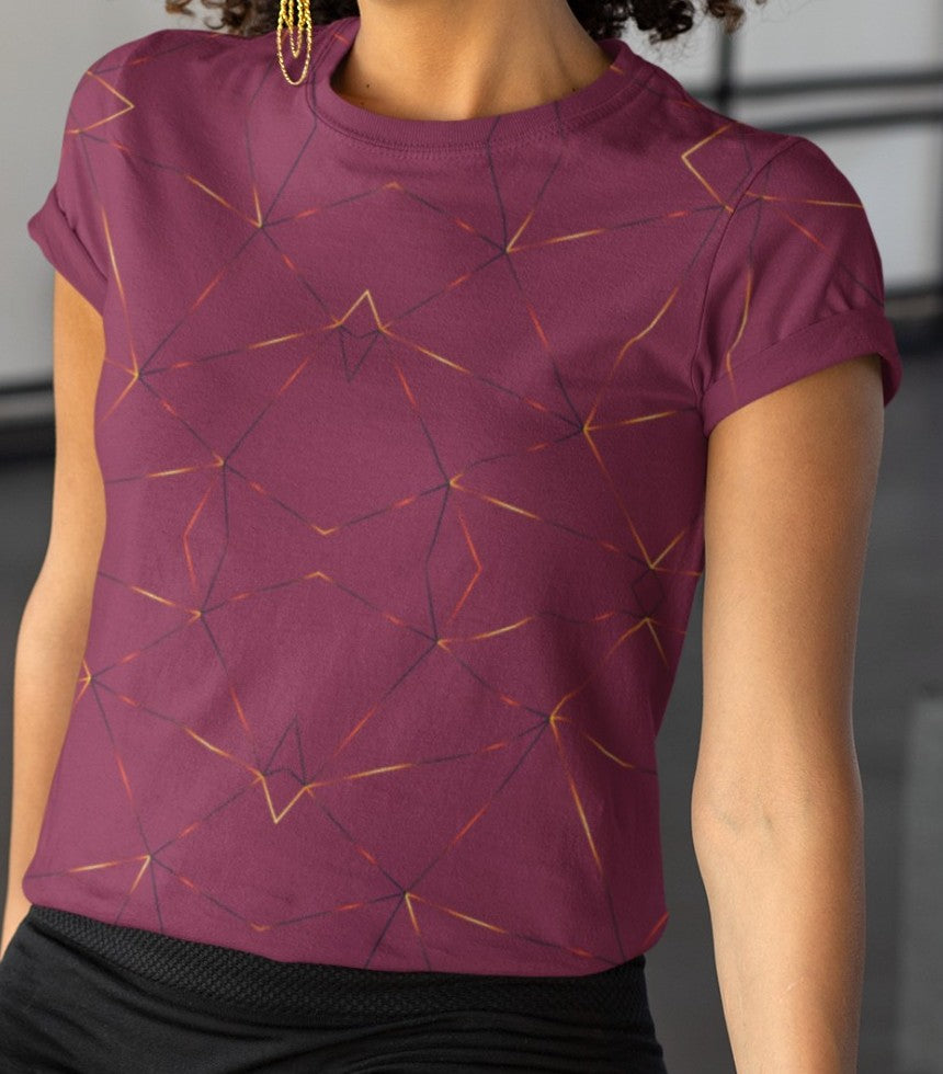 This custom designed handmade women's t-shirt is maroon in color with gold lines throughout the shirt in a geometric patterns, the lines are different shades of gold making it look like it is glowing on the shirt.