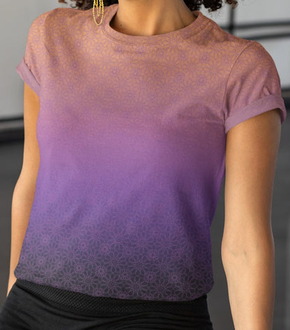 This completely custom handmade women's short sleeve tee has an ombre floral pattern with the shirt being a peach color at the neckline then fading to a lilac purple in the middle then a dark purple at the bottom, there is a lilac purple floral pattern overlayed across the top of the ombre design.