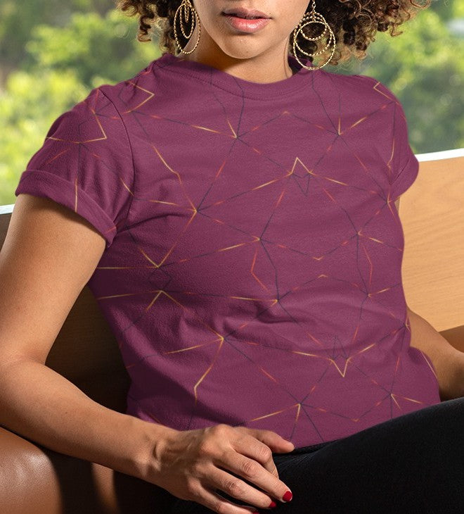 This custom designed handmade women's t-shirt is maroon in color with gold lines throughout the shirt in a geometric patterns, the lines are different shades of gold making it look like it is glowing on the shirt.
