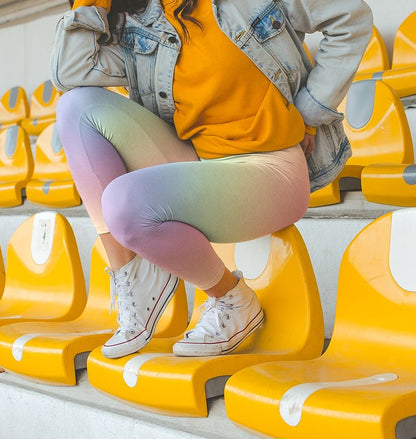 A pair of custom women's high waisted leggings with a soft gradient rainbow pattern all over the pants from top to bottom.