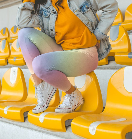 A pair of custom women's high waisted leggings with a soft gradient rainbow pattern all over the pants from top to bottom.