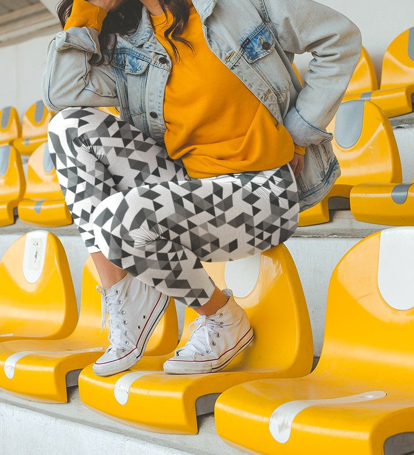 A  pair of women's handmade custom high waisted leggings, the leggings have a black, grey and white geometric pattern all across the entire pair of workout leggings.