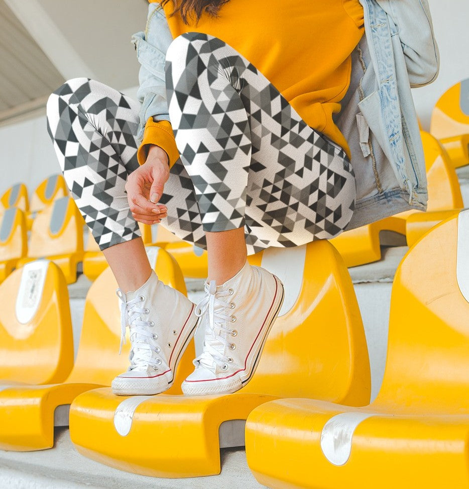 A  pair of women's handmade custom high waisted leggings, the leggings have a black, grey and white geometric pattern all across the entire pair of workout leggings.