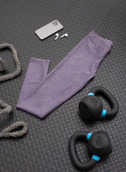 These custom handmade women's leggings are a dark purple with a beautiful gold floral pattern overlayed on the top.