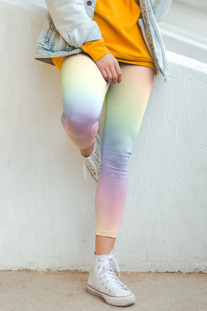 A pair of custom women's high waisted leggings with a soft gradient rainbow pattern all over the pants from top to bottom.