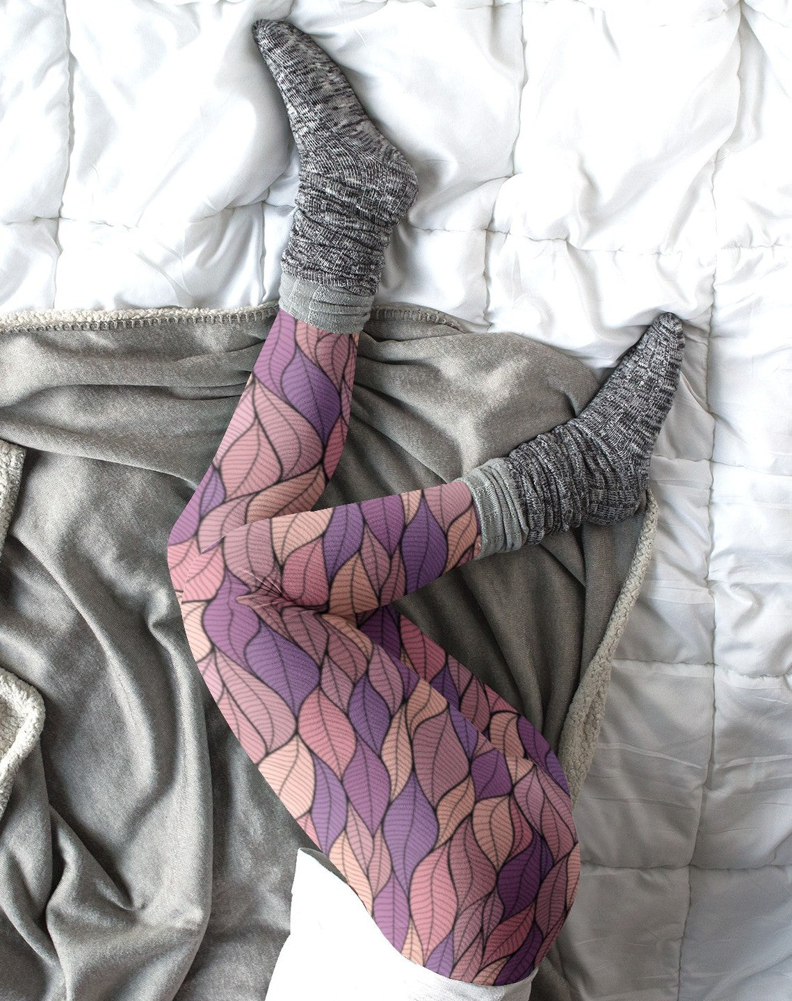 These custom colorful handmade women's leggings have a pattern of multicolored leaves from top to bottom, the leaves are light pink, purple, mauve and beige giving the leggings a vibrant look.