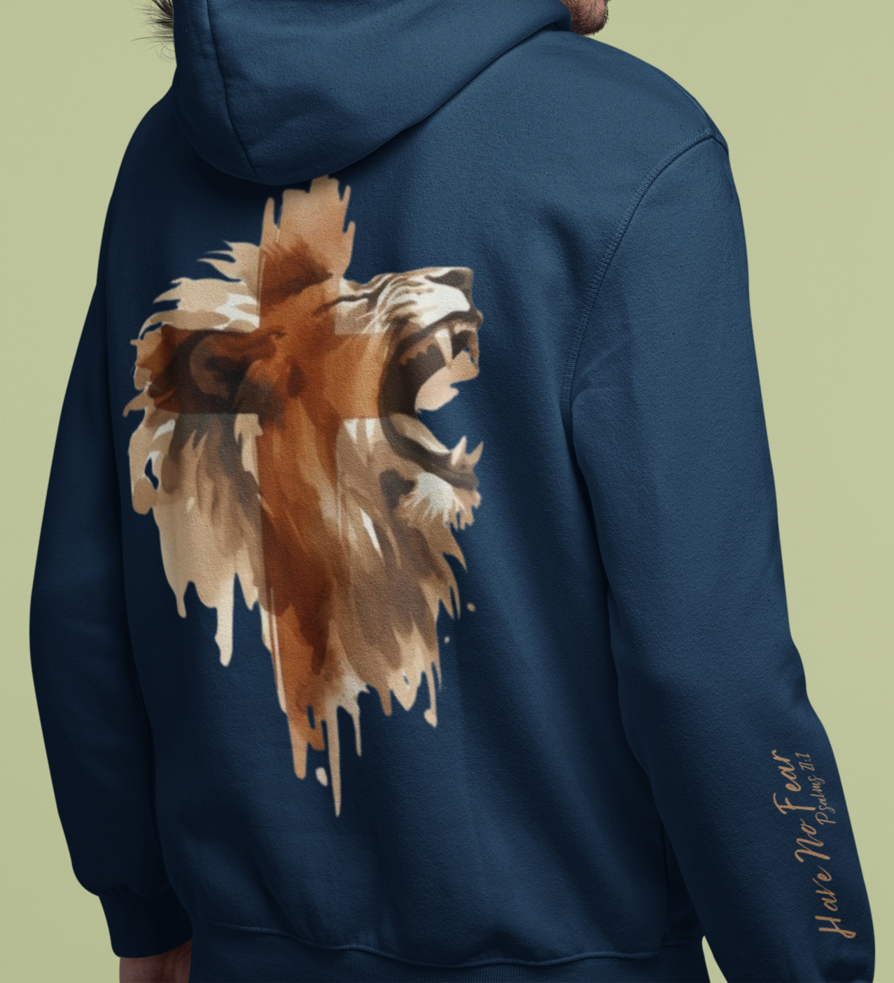 This custom Christian unisex hoodie features a image of a majestic male lion roaring with a Jesus cross overlayed overtop of the lion on the back of the hoodie, the bible verse Have No Fear Psalms 27:1 is on the right sleeve in gold cursive font.