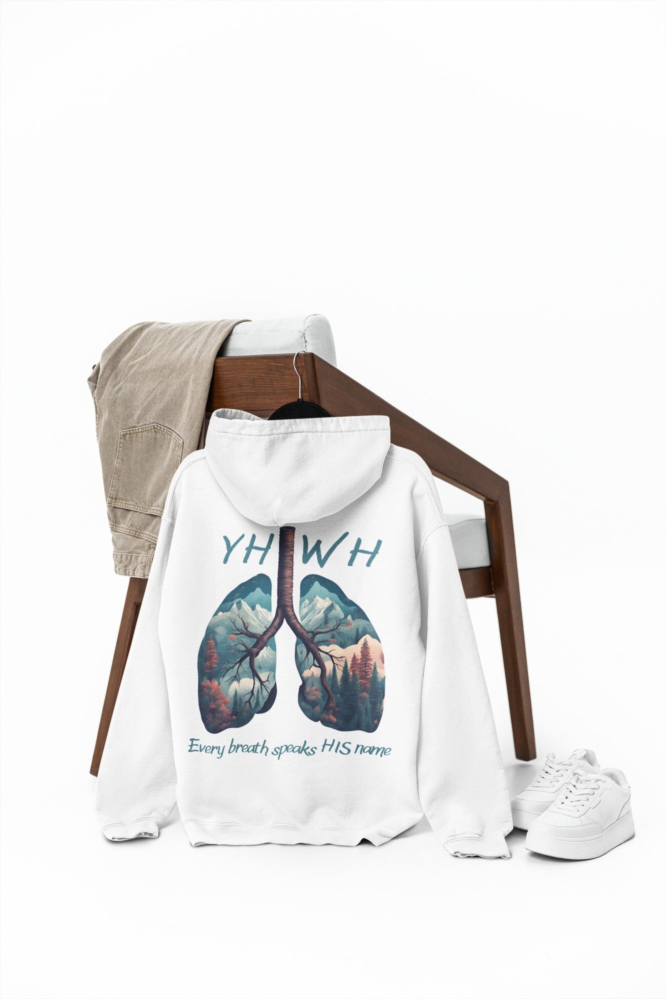 This custom Christian unisex hoodie features the letters YHWH on the front chest in light blue writing, and an image of lungs filled with a nature scene on the back with the words every breath speaks HIS name in the same color blue as the front.