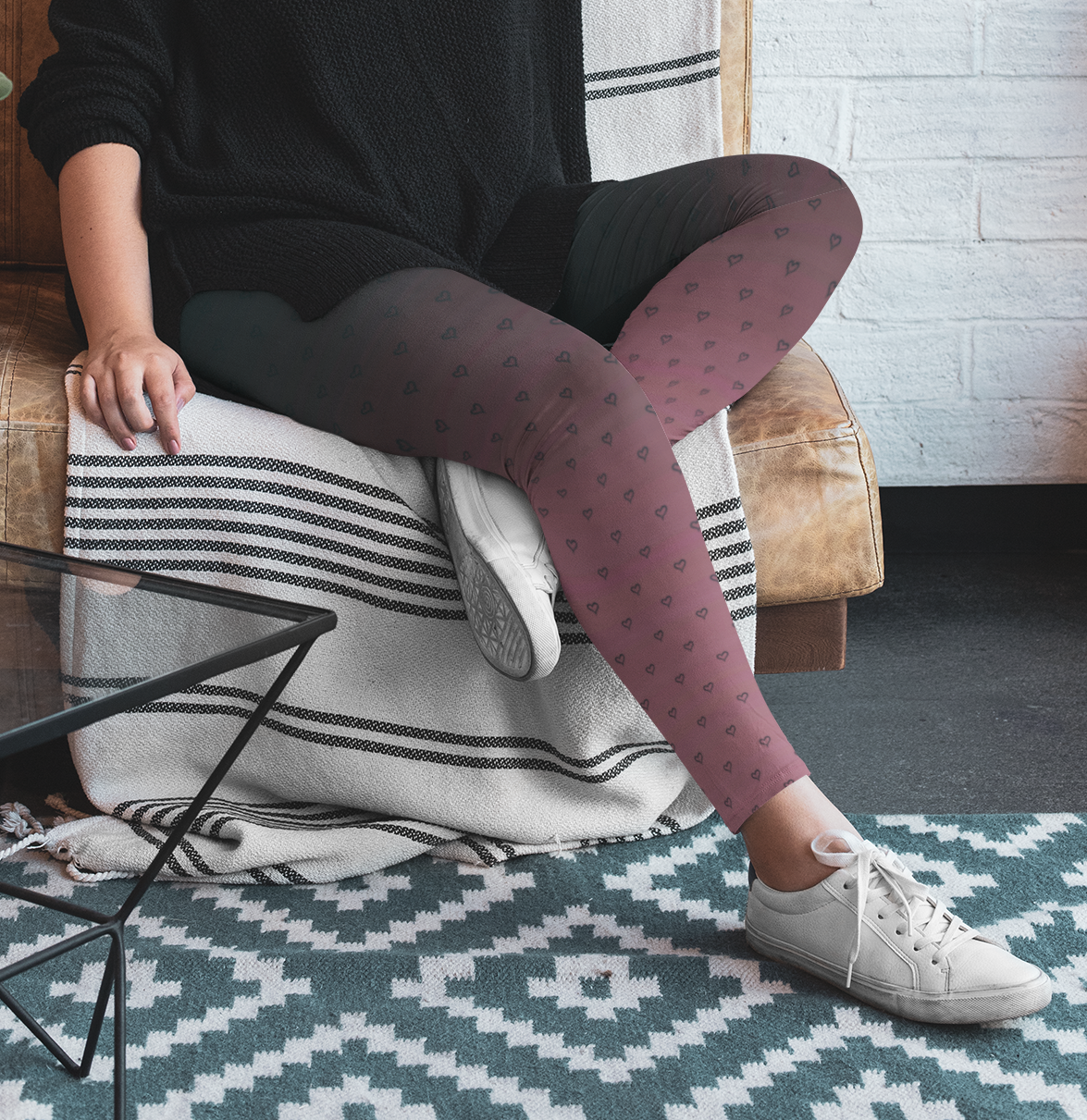 A pair of women's custom high waisted leggings that start as black at the top then fade to a light pink at the bottom, there are hearts all over the leggings then they fade into the black at the top of the pant.
