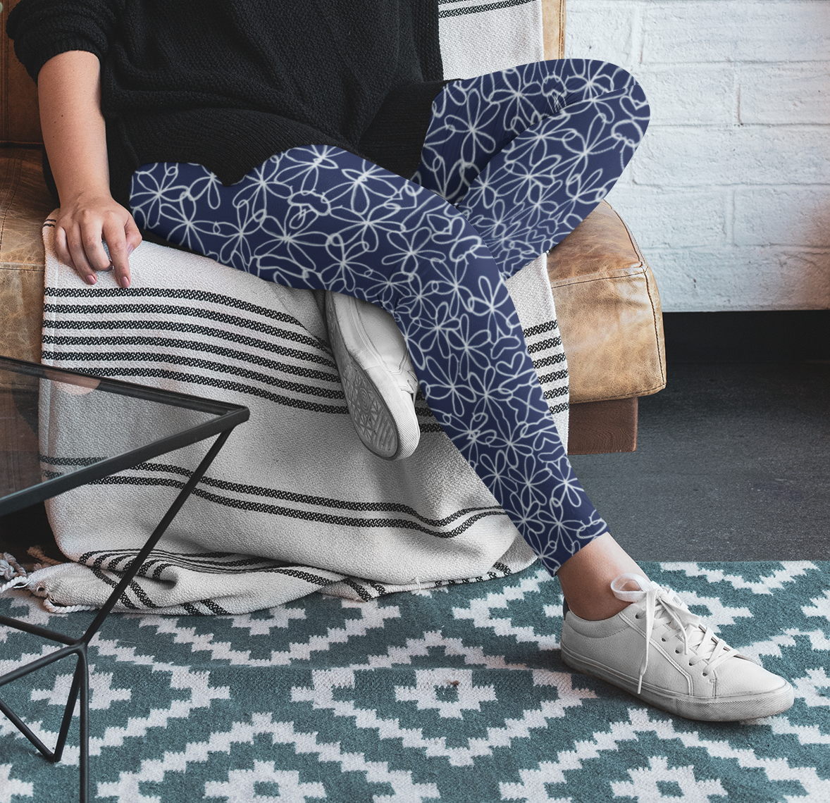 A pair of navy blue women's high waisted leggings with a white floral pattern all over the handmade pants.