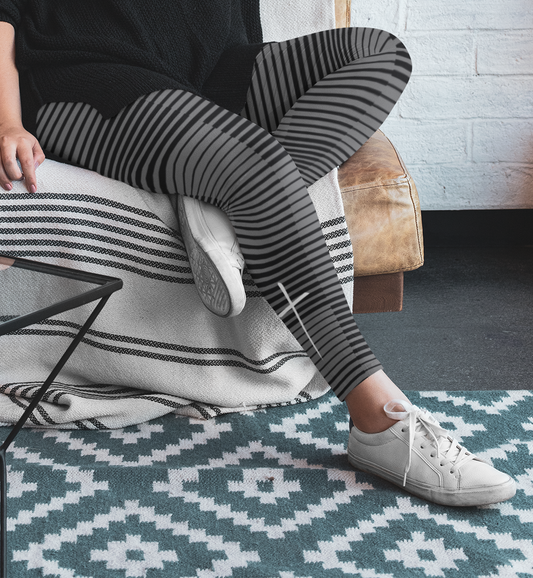 A pair of women's high waisted Christian themed leggings, the pants are light grey  color with black stripes running across the pants, the lines are in different thicknesses from the top to the bottom ankle of the leggings giving it a 3D look when worn, there is a white Jesus cross on the bottom right calf of the pant.