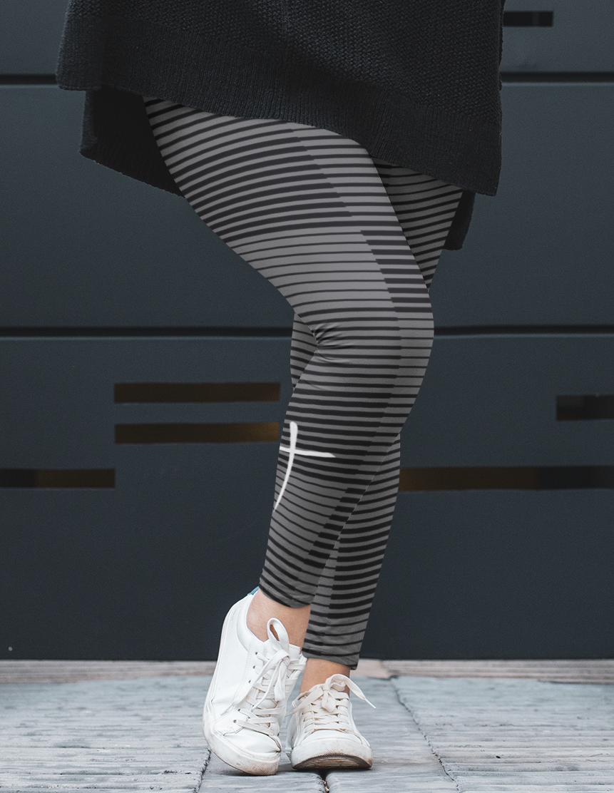 A pair of women's high waisted Christian themed leggings, the pants are light grey  color with black stripes running across the pants, the lines are in different thicknesses from the top to the bottom ankle of the leggings giving it a 3D look when worn, there is a white Jesus cross on the bottom right calf of the pant.