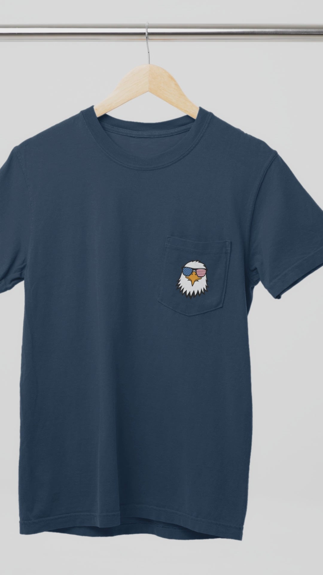 On the front of this custom t-shirt is a image of a bald eagle wearing a pair of sunglasses that have the American flag in the lenses.