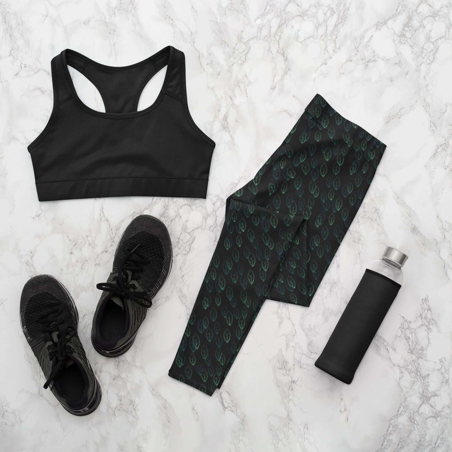 Custom high waisted women's leggings that are all black in color with a pattern of light green leaves all over the pants.