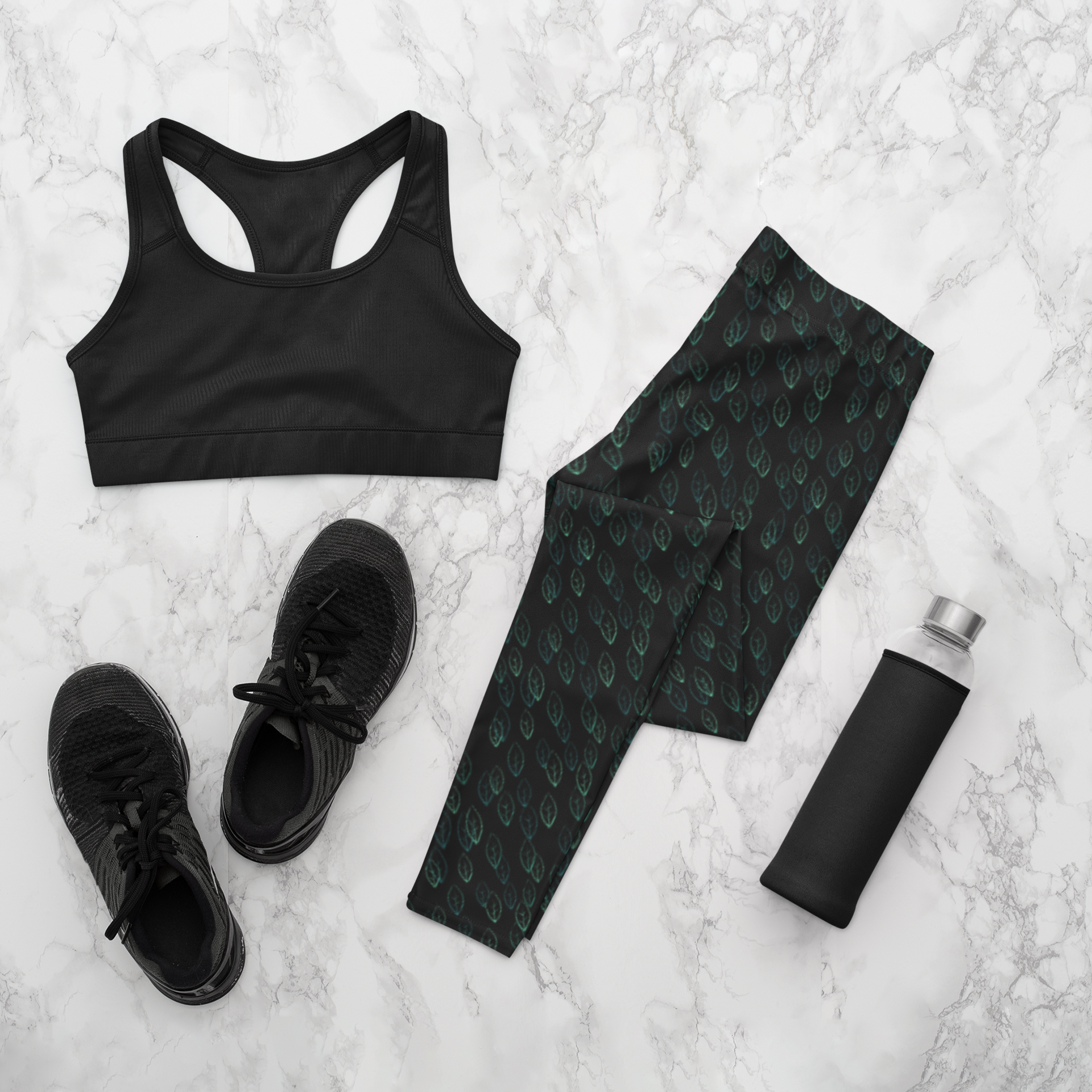 Custom high waisted women's leggings that are all black in color with a pattern of light green leaves all over the pants.