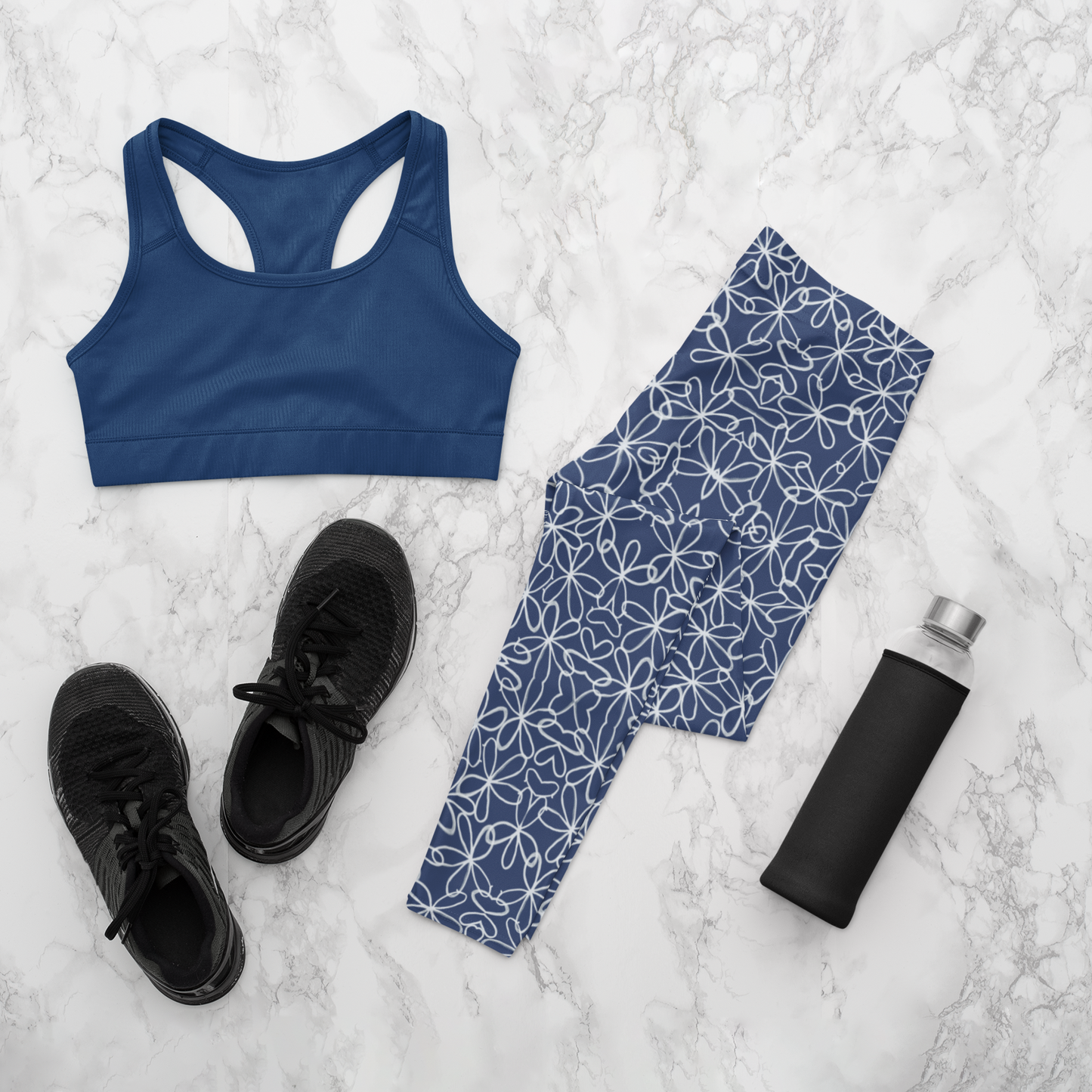 A pair of navy blue women's high waisted leggings with a white floral pattern all over the handmade pants.