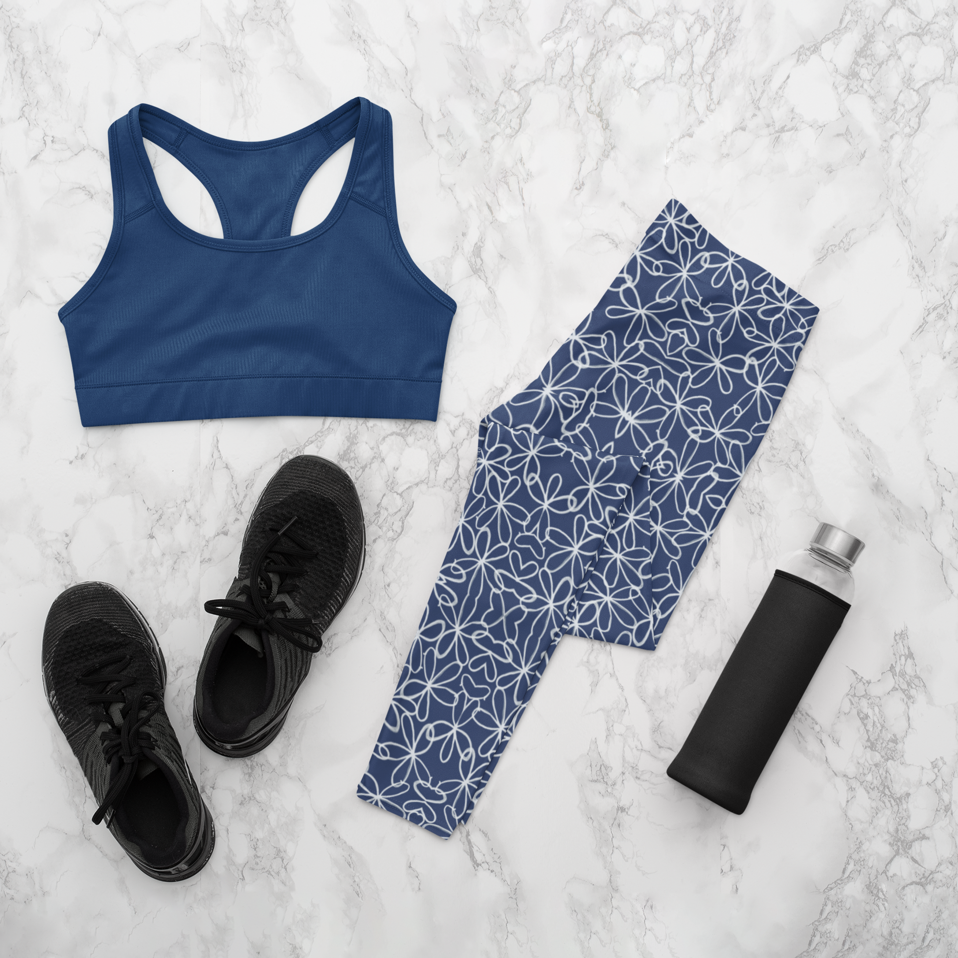 A pair of navy blue women's high waisted leggings with a white floral pattern all over the handmade pants.