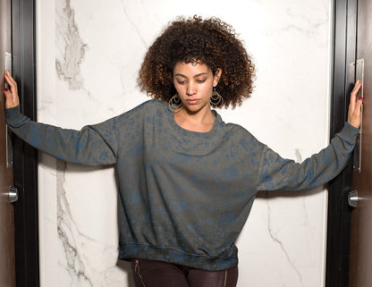 This custom women's all over print sweater has a silver to black ombre pattern starting at the neckline then fading to black at the bottom. There is a blue floral pattern overlayed on the top, perfect for anyone looking to stand out.