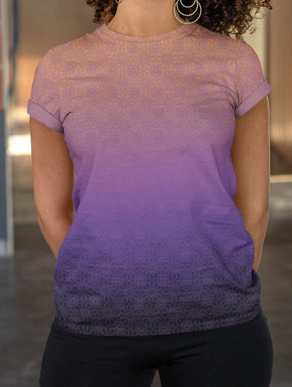 This completely custom handmade women's short sleeve tee has an ombre floral pattern with the shirt being a peach color at the neckline then fading to a lilac purple in the middle then a dark purple at the bottom, there is a lilac purple floral pattern overlayed across the top of the ombre design.