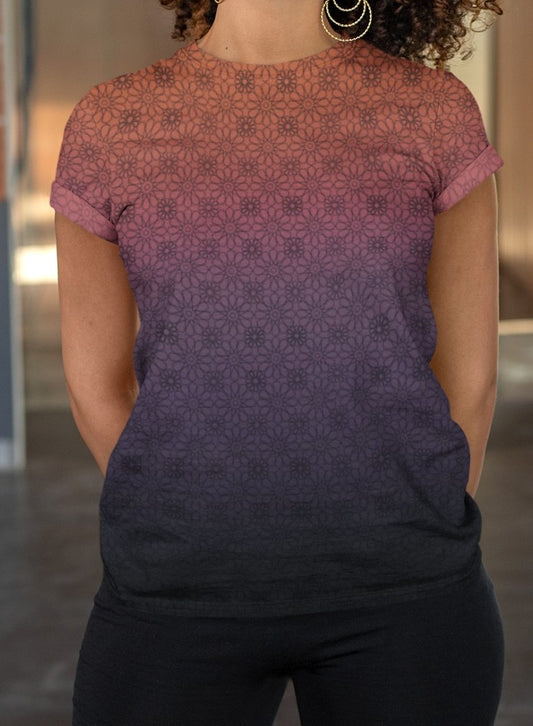 This completely custom women's handmade t-shirt has a ombre floral pattern, with the neckline being a sunset orange then it fading to a light purple then to a darker purple at the waistline of the shirt, there is a dark purple floral pattern overlayed on the top that faded into the bottom of the shirt.