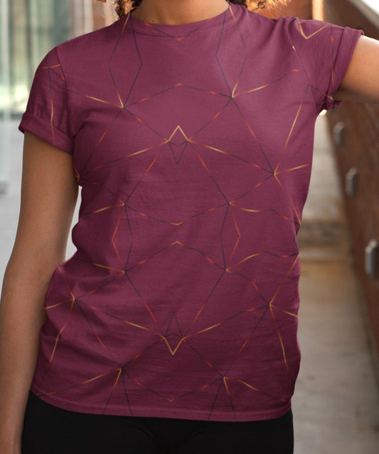 This custom designed handmade women's t-shirt is maroon in color with gold lines throughout the shirt in a geometric patterns, the lines are different shades of gold making it look like it is glowing on the shirt.