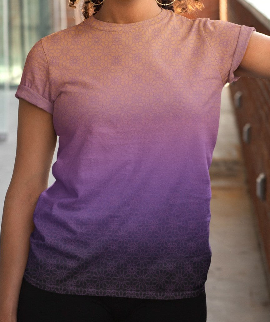 This completely custom handmade women's short sleeve tee has an ombre floral pattern with the shirt being a peach color at the neckline then fading to a lilac purple in the middle then a dark purple at the bottom, there is a lilac purple floral pattern overlayed across the top of the ombre design.