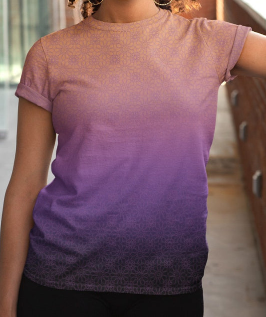 This completely custom handmade women's short sleeve tee has an ombre floral pattern with the shirt being a peach color at the neckline then fading to a lilac purple in the middle then a dark purple at the bottom, there is a lilac purple floral pattern overlayed across the top of the ombre design.