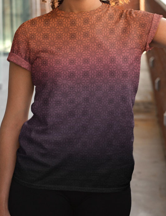 This completely custom women's handmade t-shirt has a ombre floral pattern, with the neckline being a sunset orange then it fading to a light purple then to a darker purple at the waistline of the shirt, there is a dark purple floral pattern overlayed on the top that faded into the bottom of the shirt.