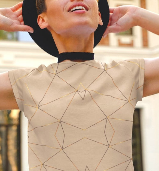This custom women's handmade short sleeve shirt is a light beige color with with gold lines all over the shirt in a geometric pattern, some spots of the gold lines are brighter than others making it seem like the gold lines are glowing.