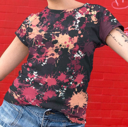 This completely custom super soft handmade women's t-shirt is all black with a bunch of different color paint splashes all over the shirt from red, pink, peach, burgundy, maroon and white. This shirt is perfect for painters or people who love art