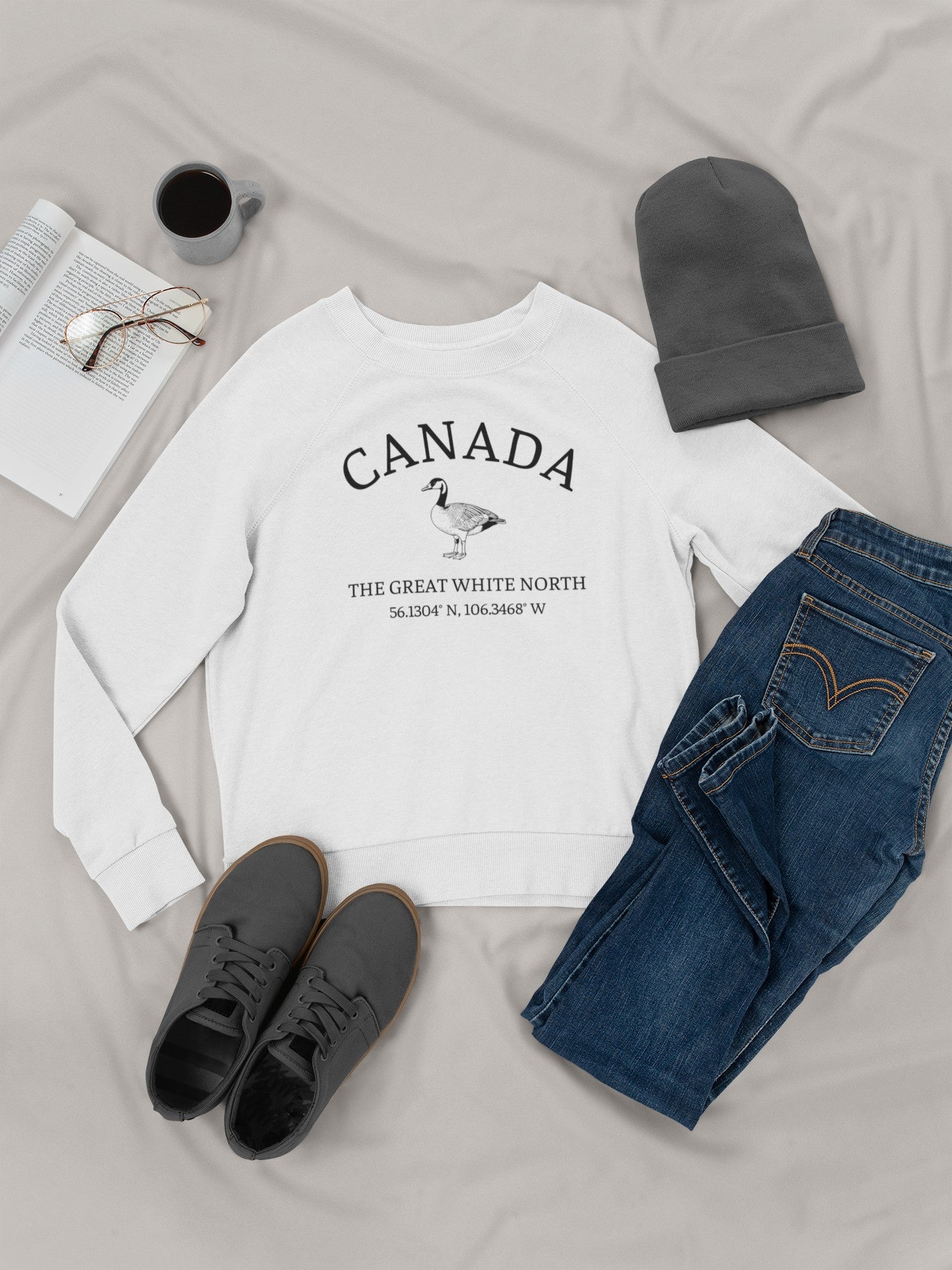 On the front of this unisex super soft Canadian sweatshirt is the word Canada in large text on the top with an image of a Canadian Goose underneath. Under the Goose are the words The Great White North with Canada's geological location under that.