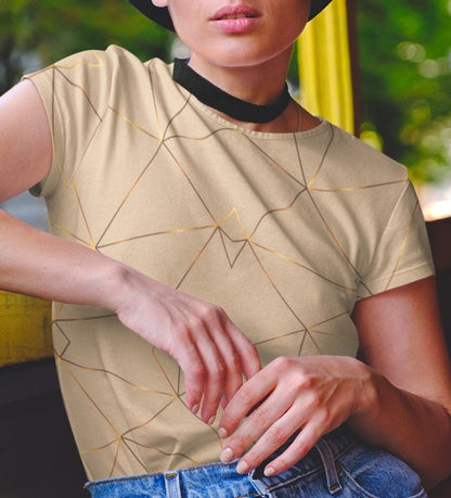 This custom women's handmade short sleeve shirt is a light beige color with with gold lines all over the shirt in a geometric pattern, some spots of the gold lines are brighter than others making it seem like the gold lines are glowing.