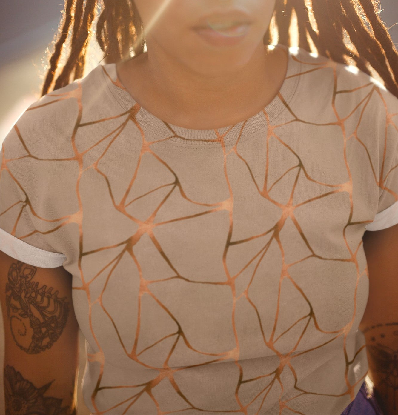 This all over print handmade women's custom t-shirt is beige all over with copper lines that go in a abstract pattern, the copper lines shine more in some places then in others giving it a metallic look.