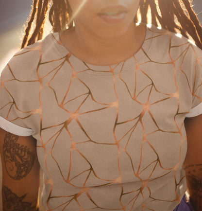 This all over print handmade women's custom t-shirt is beige all over with copper lines that go in a abstract pattern, the copper lines shine more in some places then in others giving it a metallic look.