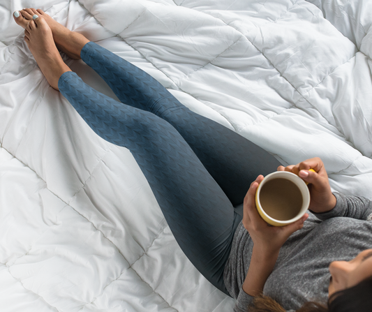 A pair of high waisted women's handmade custom leggings with a ombre pattern that starts as black at the waistline then shifts to a deep blue color at the bottom, there is a black wave pattern that is superimposed overtop and it blends into the black at the waistline.